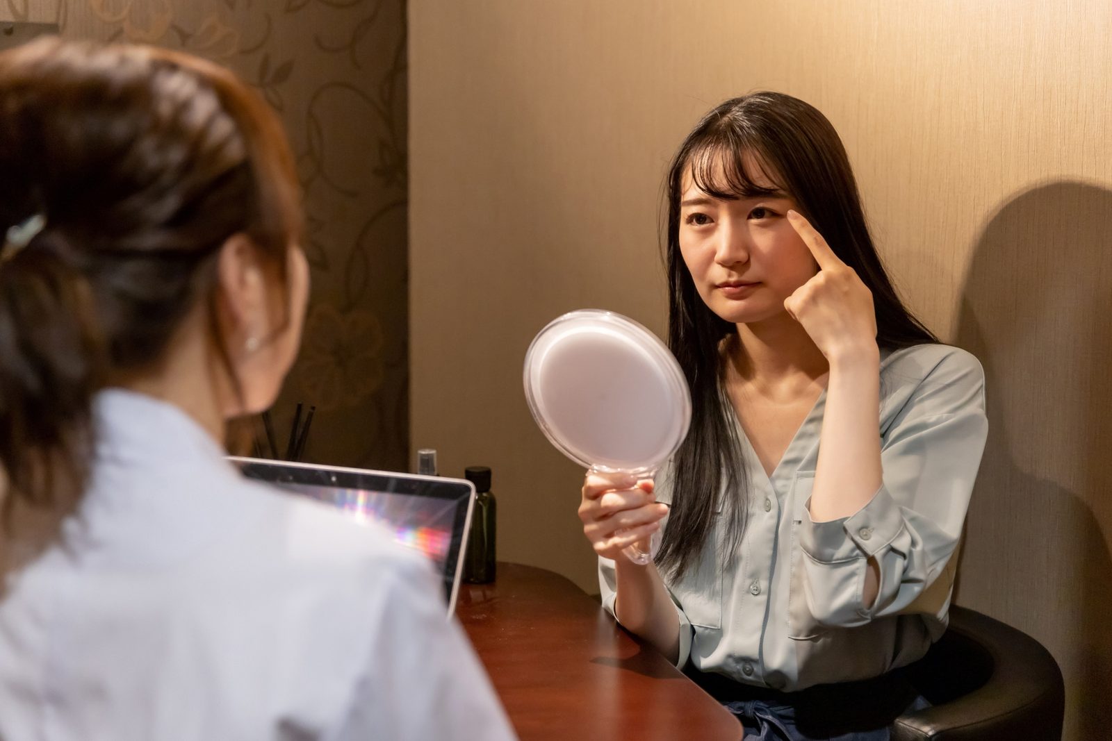 まつ毛パーマの前に目元の不安やアレルギー歴をアイリストに相談するお客様